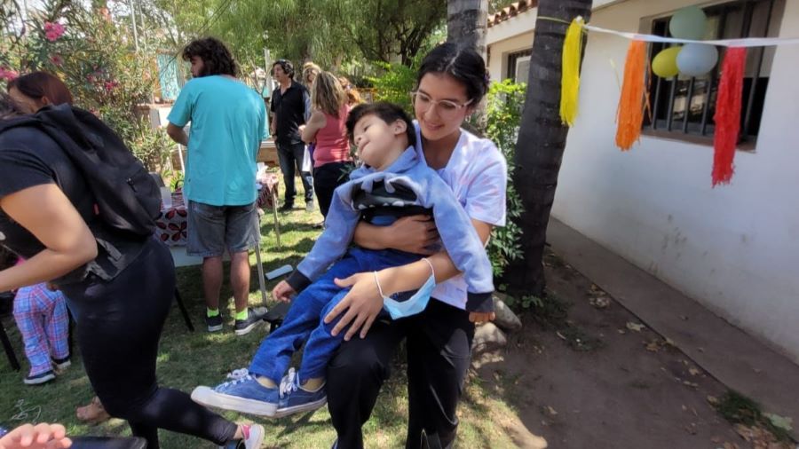 Paciente del servicio de rehabilitación del centro de salud municipal en brazos de una profesional