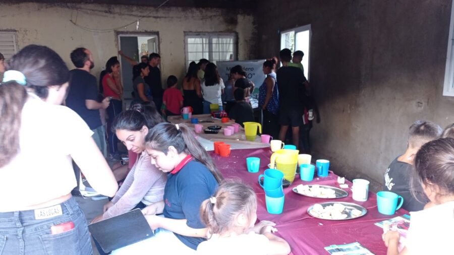 Niños recibiendo útiles escolares en el merendero