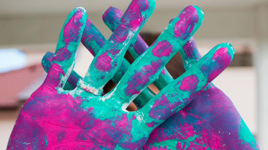 Manos manchadas con pintura azul y rosa. Mucho para aprender en Mendiolaza